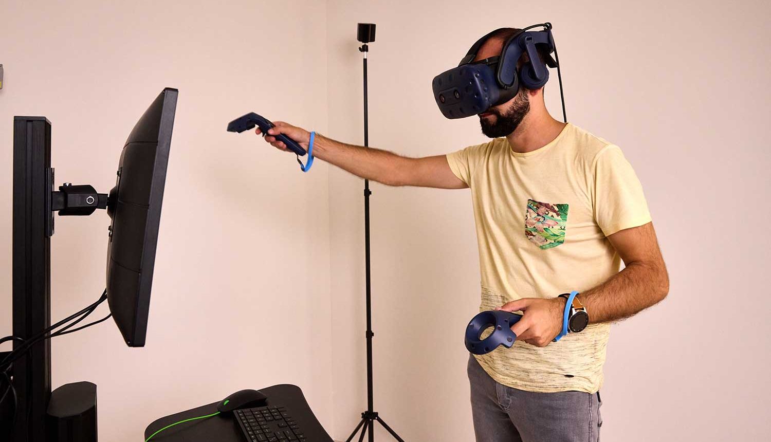 Jeune homme portant un casque à réalité virtuelle et une manette dans chaque main